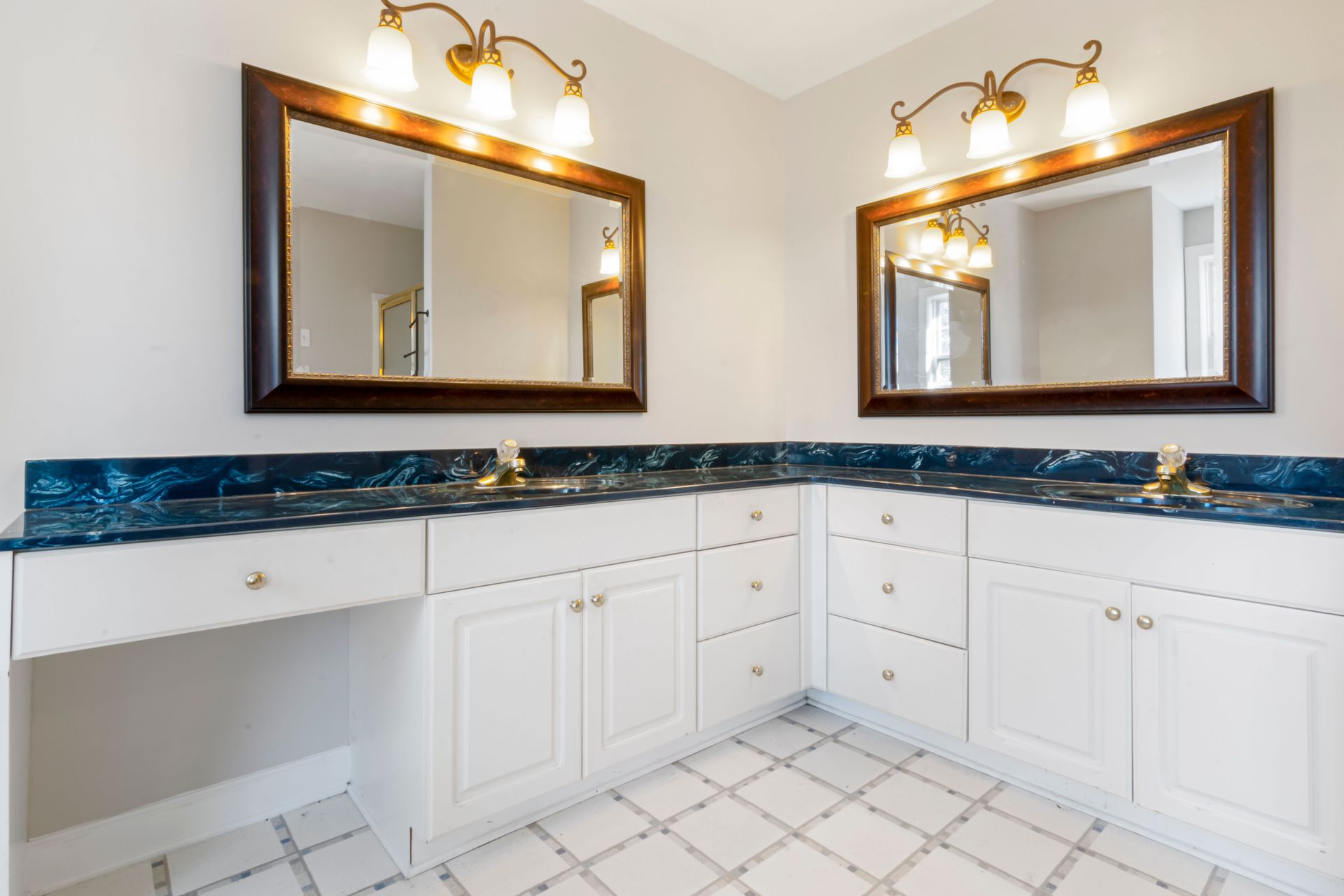 Spacious bathroom with dual mirrors, elegant lighting, and modern countertop design.