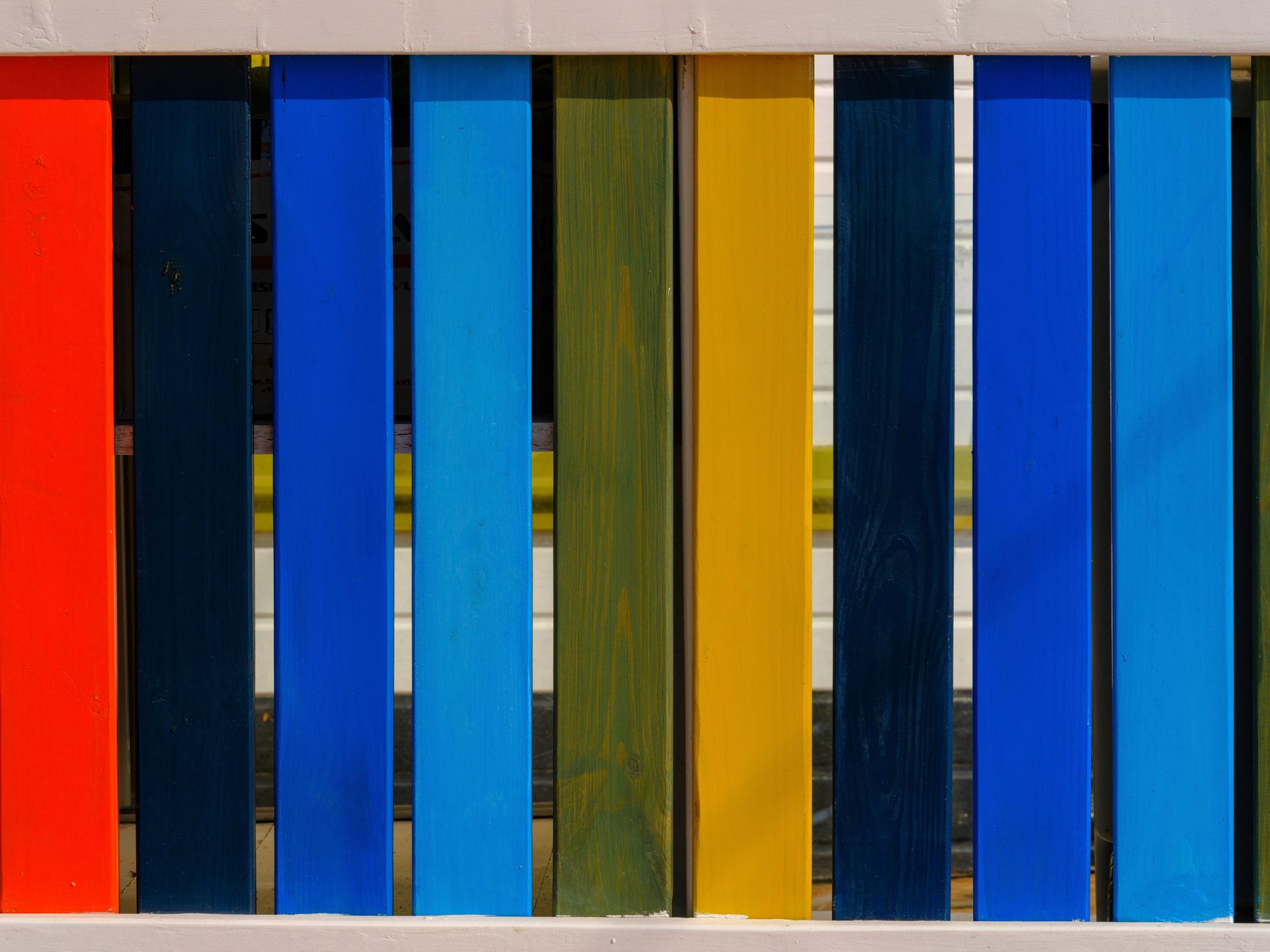 Close-up of a vibrant wooden fence with multicolored vertical planks.